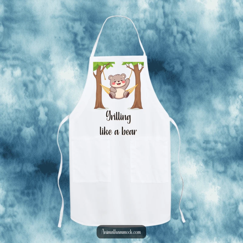 Funny chubby bear cub gleefully dangling from a hammock strung between two trees, adorning this humorous apron.