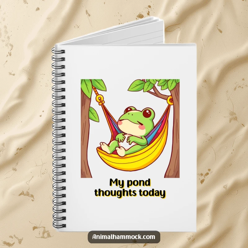 Funny frog character relaxing in a brightly colored hammock, featured on a notebook cover for creative minds.