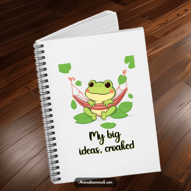 Funny green frog with a wide grin relaxing in a hammock on a notebook, perfect for peaceful thoughts.