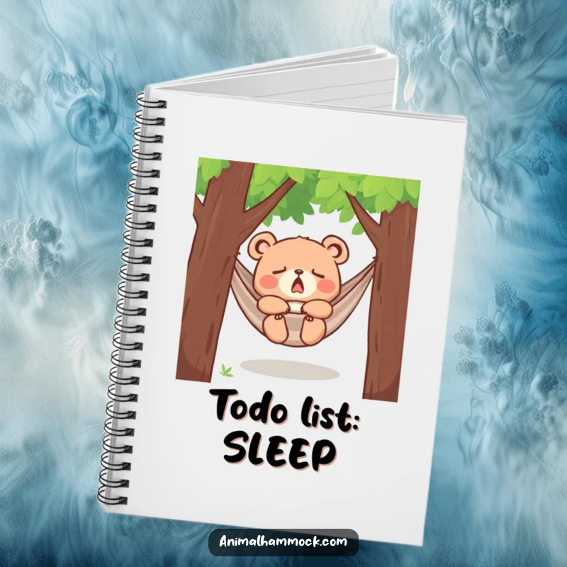 Funny yawning bear cub dozing in a hammock between trees, printed on a notebook cover, inspiring peaceful thoughts and offering a humorous touch.